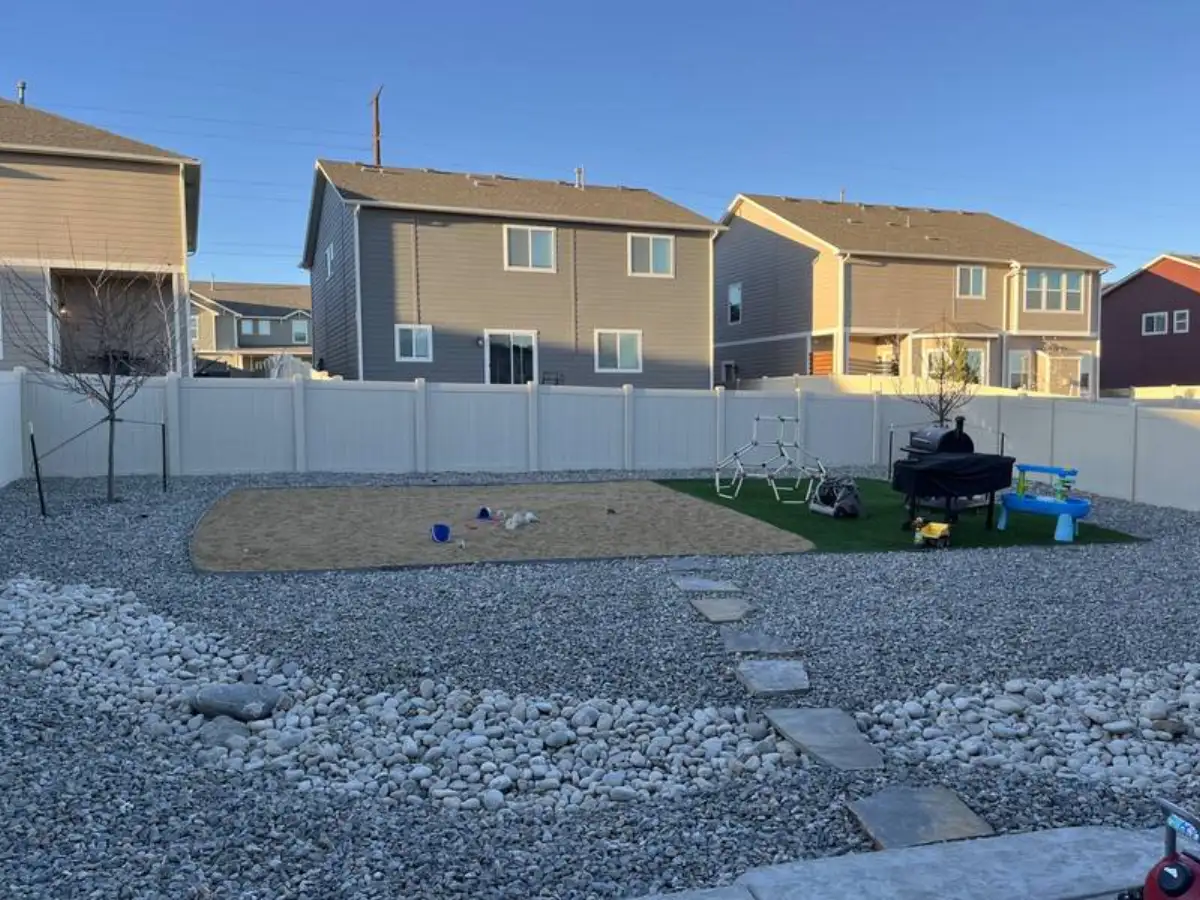 Backyard with artificial turf patch, stepping stones, and sand pit