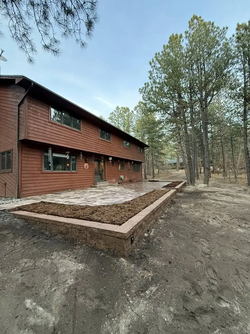 Paver patio with raised planter bed in pine setting in Colorado Springs