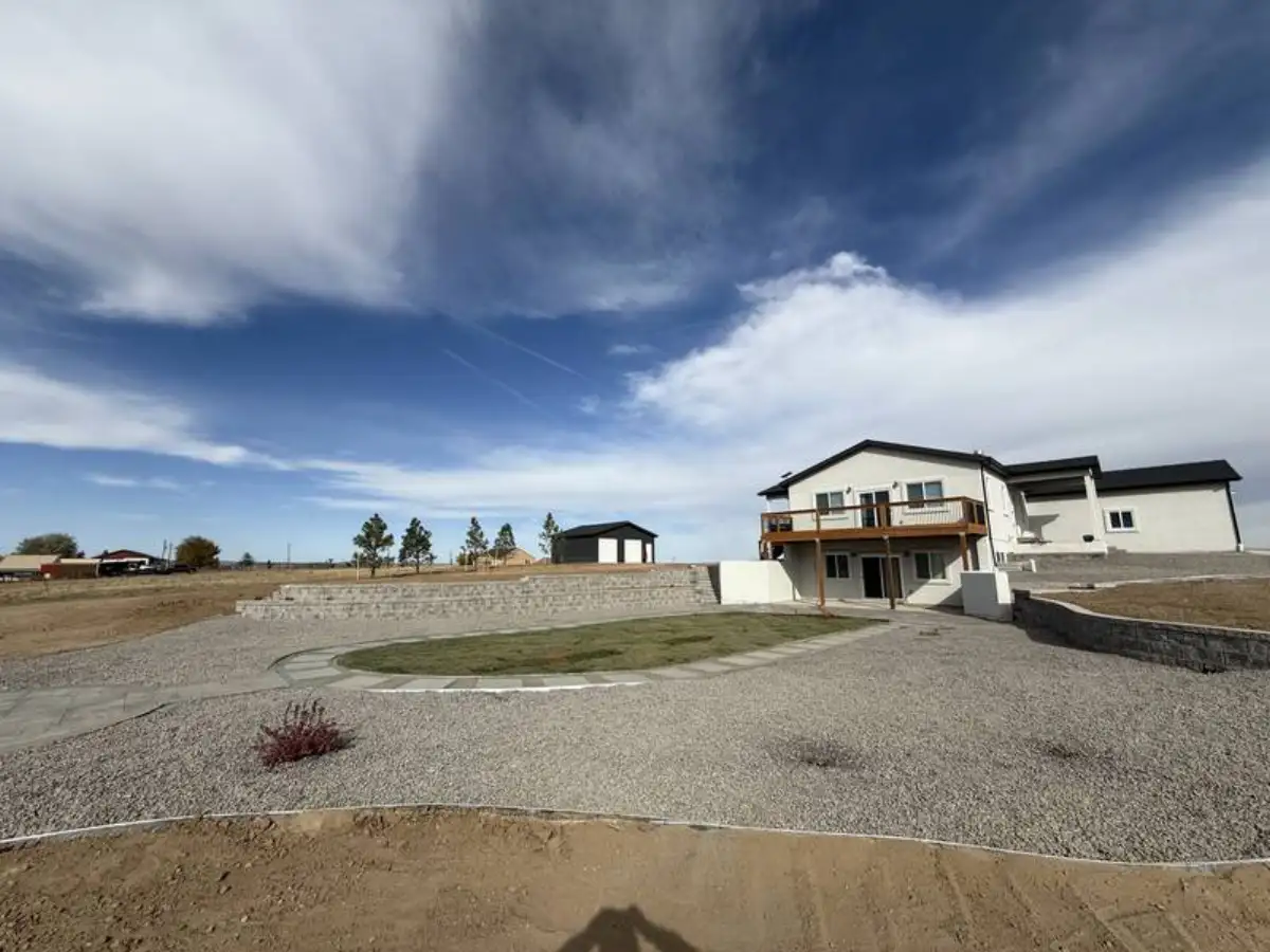 Full property outdoor living space with paver patio, retaining wall, and grass island