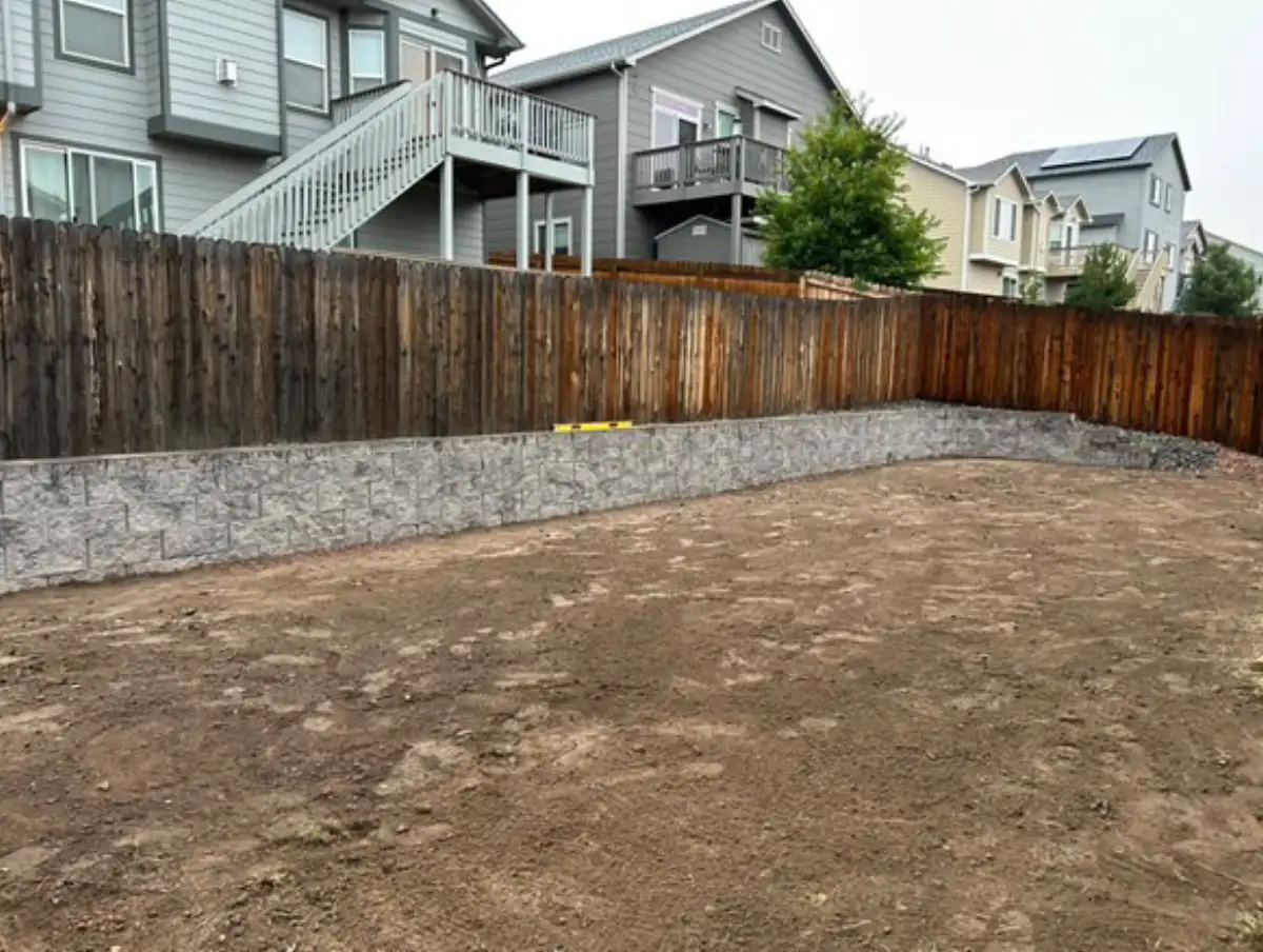 Retaining wall installation along fence line in Colorado Springs