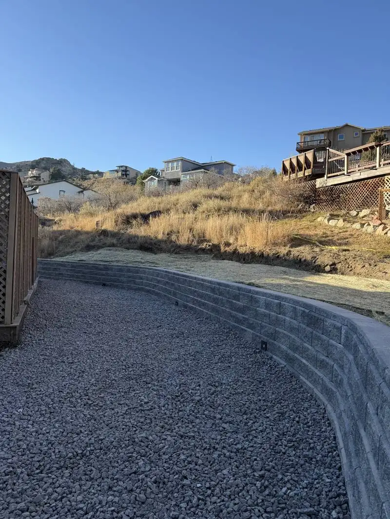 Curved block retaining wall built on a hillside in Colorado Springs